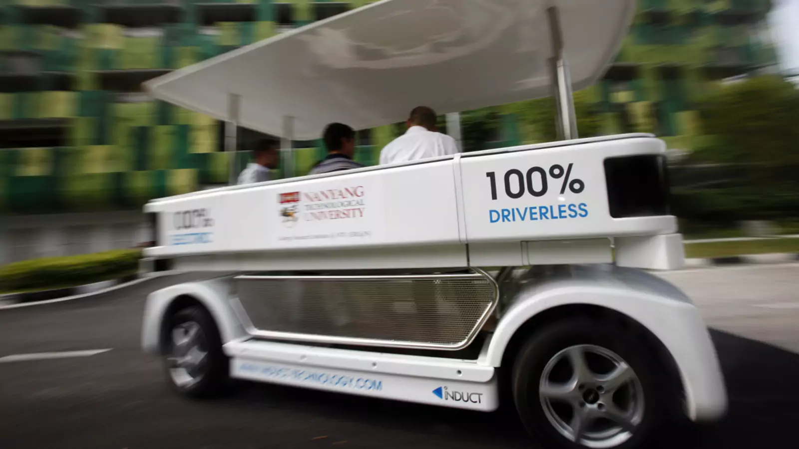 People ride on a driverless electric vehicle at the Nanyang Technological University (NTU) in Singapore.