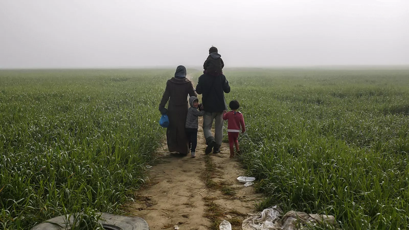 A family walks through a camp for migrants and refugees outside Idomeni, Greece, along the border with Macedonia, in 2016.