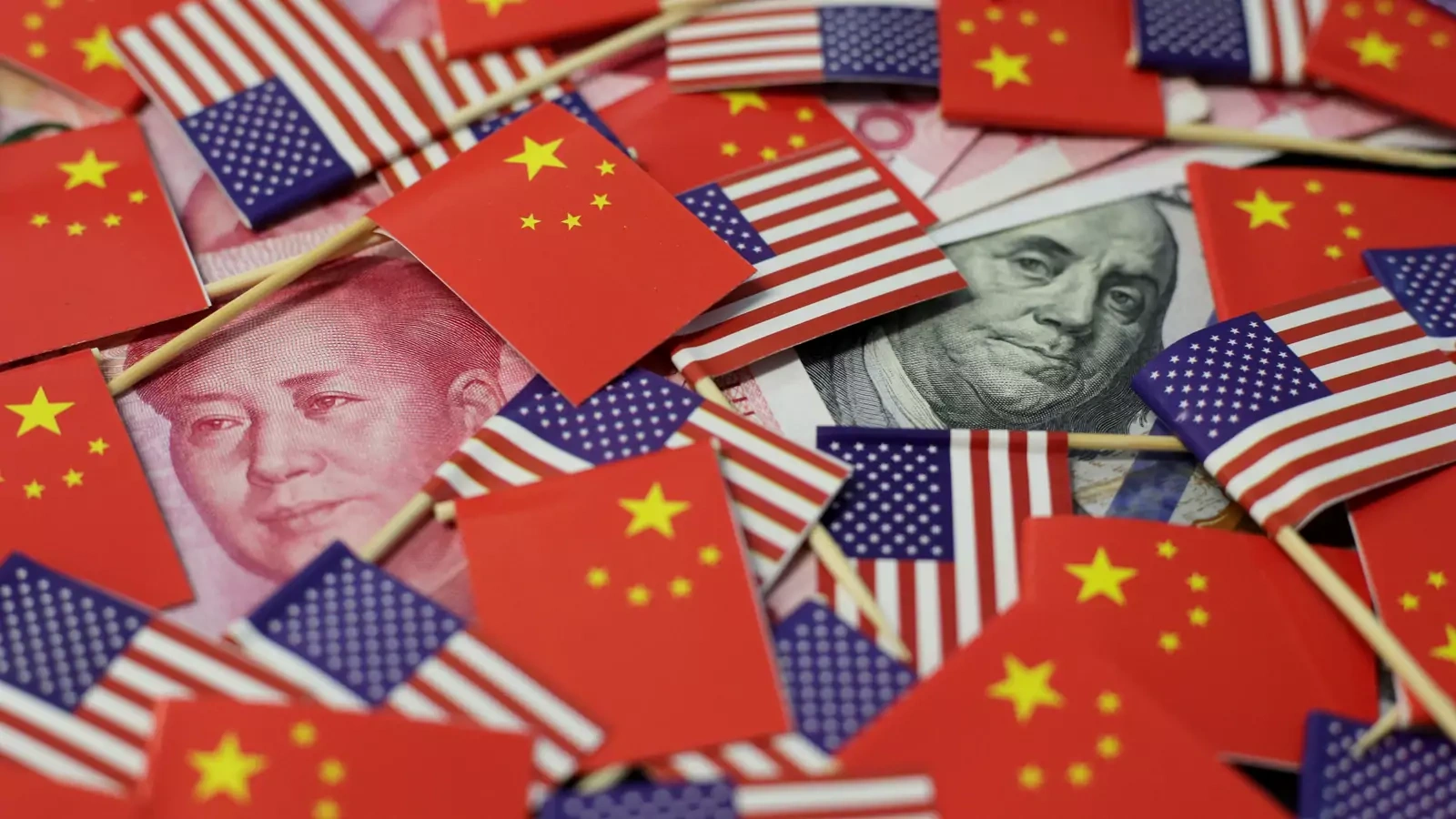 A U.S. dollar banknote featuring American founding father Benjamin Franklin and a China's yuan banknote featuring late Chinese chairman Mao Zedong are seen among U.S. and Chinese flags in this illustration picture taken May 20, 2019. 
