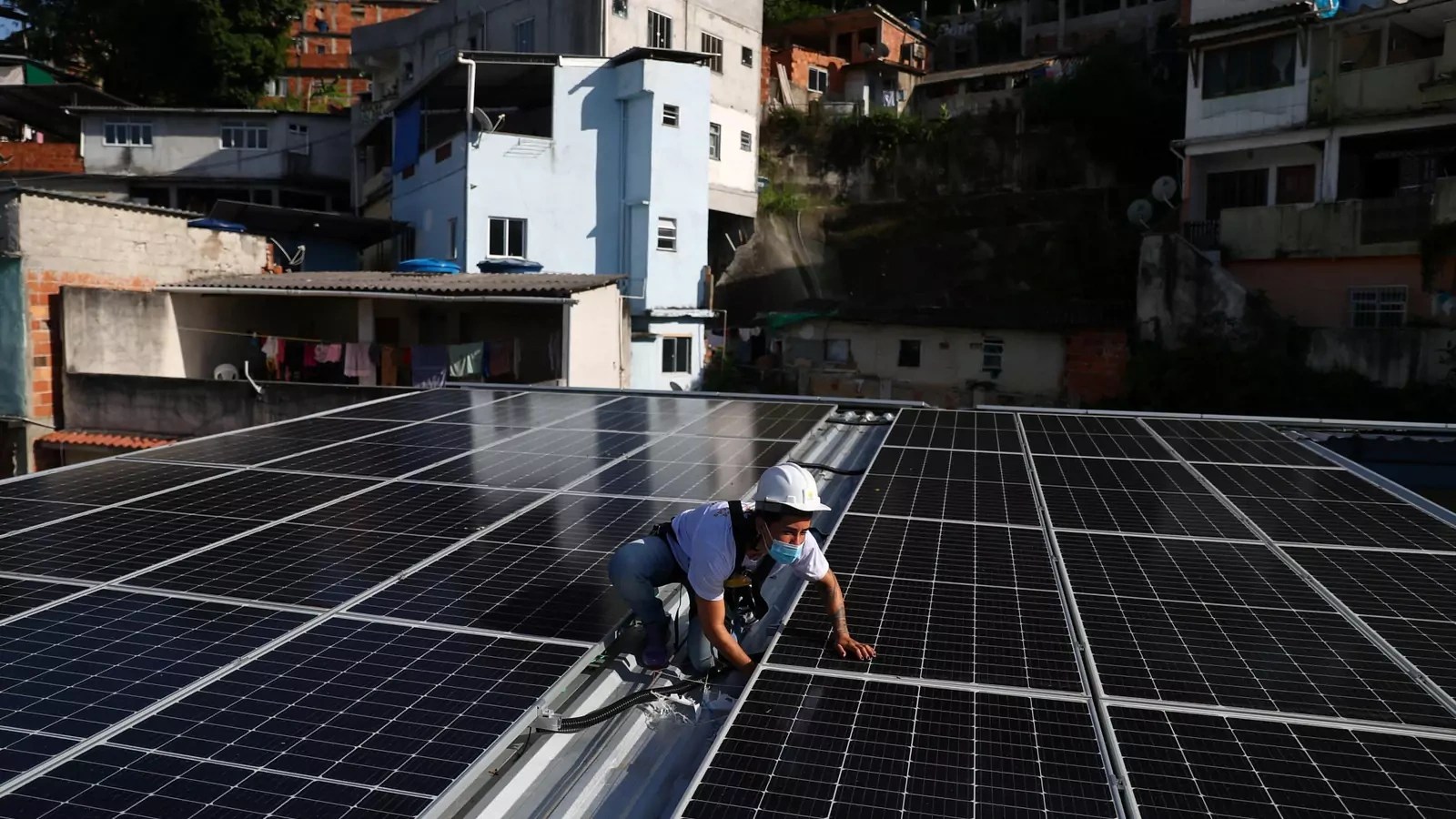 A worker installs solar panels in Rio de Janeiro