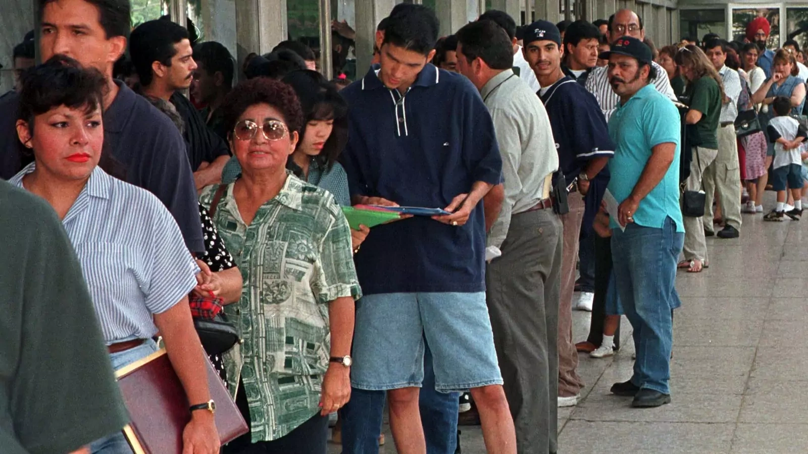 A group of immigrants, who qualify for residency in the United States but do not yet have their legal papers, stand in line at the Immigration and Naturalization Service offices in Los Angeles. 