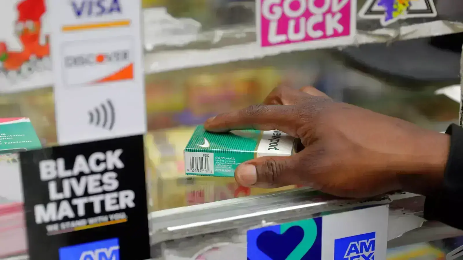 A customer picks up a pack of Newports at Evergreen Smoke Shop in Oakland, California.