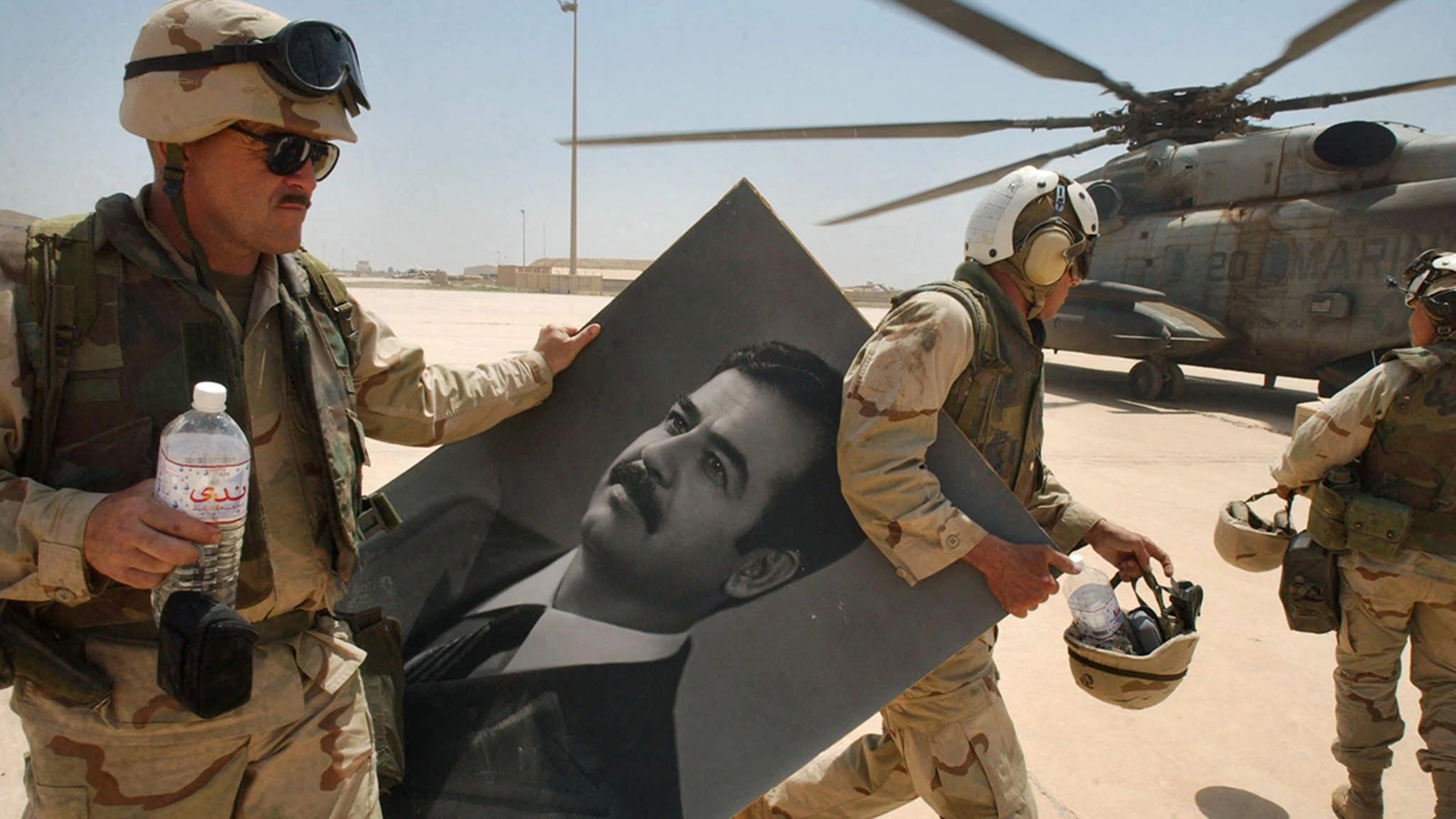 U.S. Marines carry a portrait of toppled Iraqi President Saddam Hussein at Baghdad’s international airport in April 2003.  