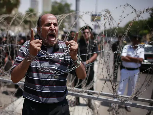  A protester shouts in front of police outside the Supreme Constitutional Court, where a decision is expected on the validity of the law passed by the Islamist-led parliament that sought to bar Ahmed Shafik in Cairo June 14, 2012 (Suhaib Salem/Courtesy Reuters). 