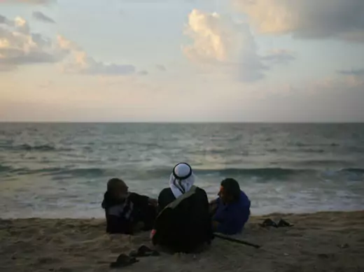 Palestinians sit on the beach in Gaza City.
