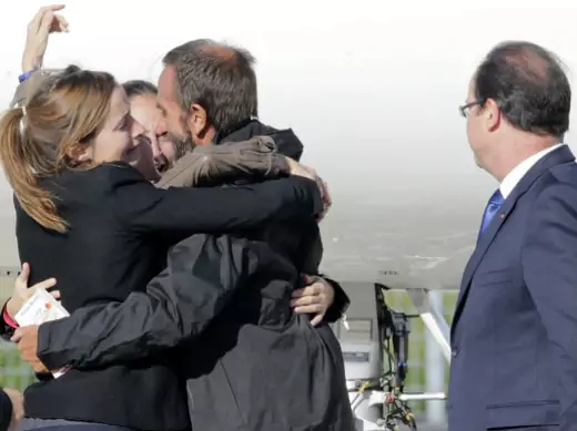 Former French hostage Daniel Larribe is welcomed by relatives as French President Francois Hollande looks on on the tarmac upon their arrival at Villacoublay military airport, near Paris, October 30, 2013 (Jacky Naegelen/Courtesy Reuters).