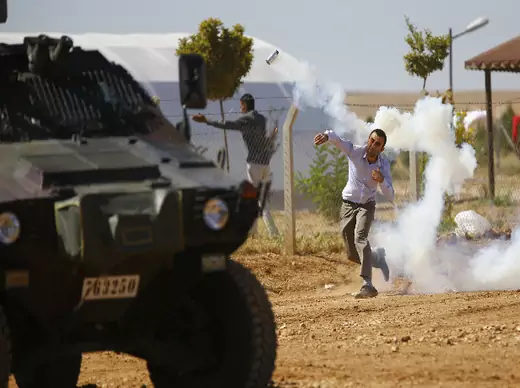 A Turkish Kurdish protester throws a tear gas canister back at Turkish soldiers near the Mursitpinar border crossing on the Turkish-Syrian border in the Turkish town of Suruc in southeastern Sanliurfa province October 4, 2014 (Sezer/Courtesy Reuters).