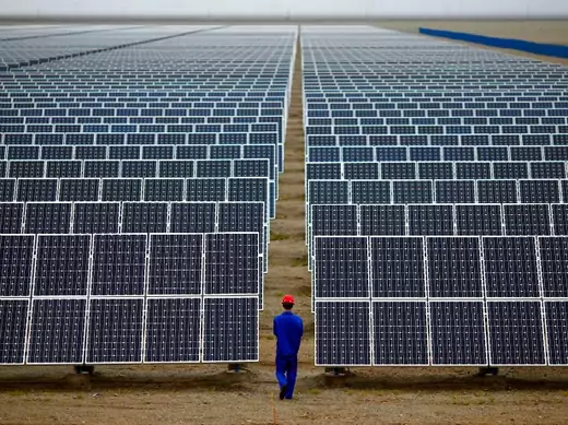 A worker inspects solar panels at a solar Dunhuang, 950km (590 miles) northwest of Lanzhou, Gansu Province September 16, 2013. China is pumping investment into wind power, which is more cost-competitive than solar energy and partly able to compete with coal and gas. China is the world's biggest producer of CO2 emissions, but is also the world's leading generator of renewable electricity. Environmental issues will be under the spotlight during a working group of the Intergovernmental Panel on Climate Change