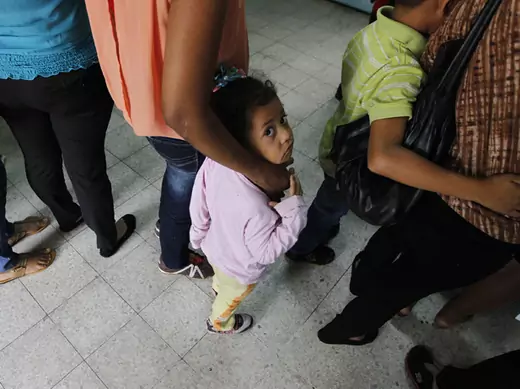 Women and their children wait in line to register at the Honduran Center for Returned Migrants after being deported from Mexico, in San Pedro Sula