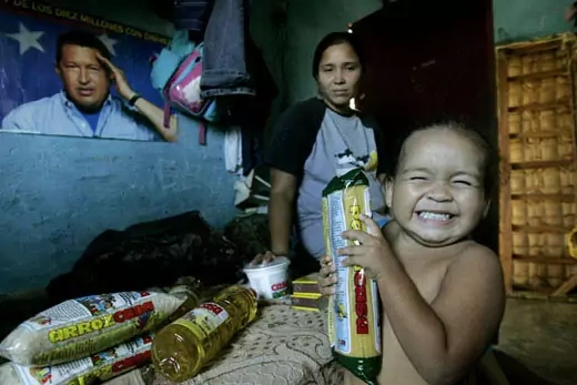 A child displays food from a discount government grocery store. AP Images/Fernando Llano