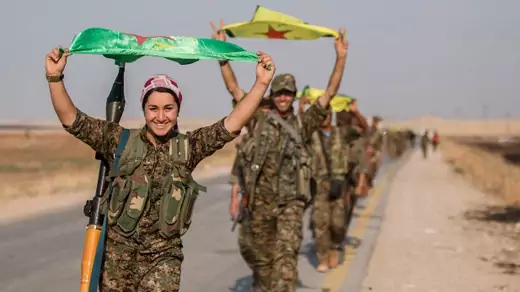 Kurdish fighters gesture while carrying their parties' flags in Tel Abyad of Raqqa governorate after they said they took control of the area June 15, 2015 (Reuters/Rodi Said).