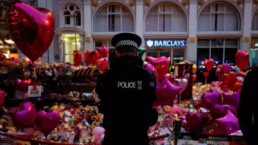 UK police officer stands at a vigil for the victims of the terrorist attack in Manchester.