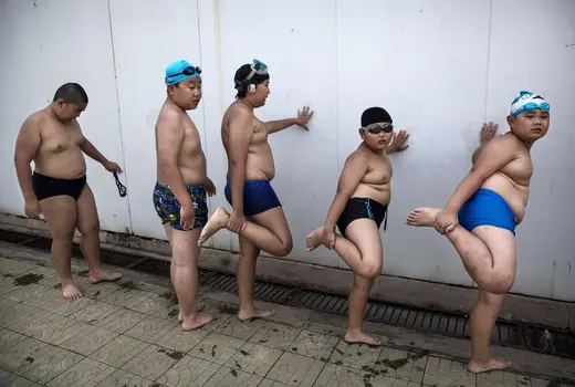 Chinese students stretch for swimming in Beijing. More investment is needed to prevent and reduce the unhealthy lifestyles that spur NCDs, but few countries, poor or wealthy, have managed to lower health risks such as childhood obesity