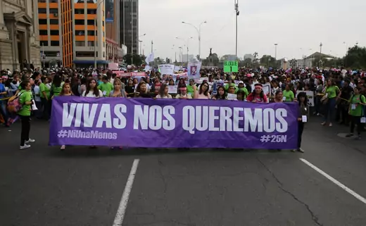Women in Peru march holding sign reading: ' We want us alive' during a protest against violence against women, November 25, 2017.