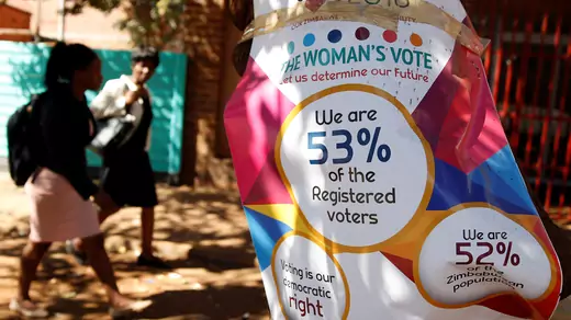 Women walk past Zimbabwe Electoral Commission (ZEC) posters in Harare, Zimbabwe, July 26, 2018. 