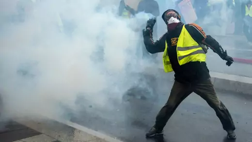 A Yellow Vests protester throws a tear gas canister in Nantes, France.
