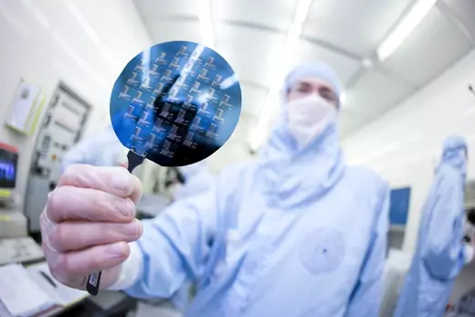 A researcher presents a silicon wafer.