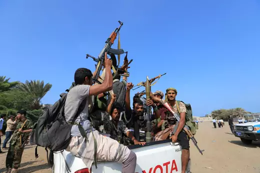 Houthi militants ride on the back of a truck.