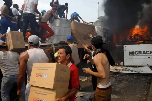 Opposition supporters unload humanitarian aid from a truck that was set on fire after clashes between opposition supporters and Venezuela's security forces February 2019