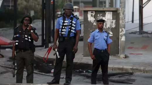 Three armed police officers stand in front of the Novare Shoprite Mall in Lekki, near Lagos, Nigeria, after it was looted, on September 3, 2019.