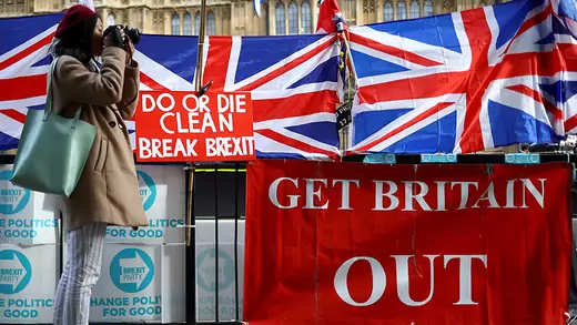 Red sign reading "Get Britain Out" along with UK flags with sign "Do or die clean break Brexit."
