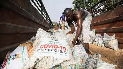 Men load sacks of rice, which have the words "COVID-19: Palliative for the Vulnerable People" plastered on them, among other food aid in a truck, to be distributed for those affected by procedures taken to curb the spread of coronavirus disease (COVID-19), in Abuja, Nigeria, on April 17, 2020.
