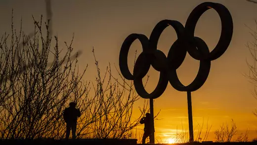 People pose for pictures in front of the Olympic rings in the Olympic Park in London, United Kingdom.