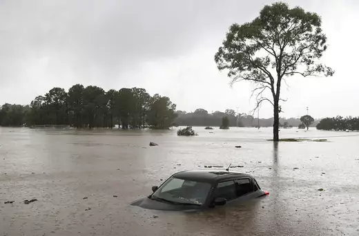 A partially submerged car is seen abandoned in floodwaters in the suburb of Windsor as the state of New South Wales experiences widespread flooding and severe weather, in Sydney, Australia, March 22, 2021.