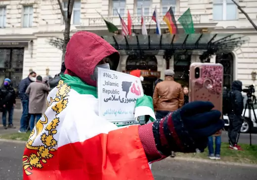 A protester with the Lion and Sun flag of the National Council of Resistance of Iran, an Iranian opposition group, takes a selfie in front of the Grand Hotel in Vienna on April 6, 2021, where diplomats of the EU, China, Russia and Iran hold talks.