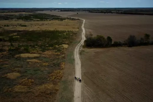 A group of migrants walk past plowed farmland after crossing into the United States from Mexico, as they make their way towards a gap in the border wall to surrender to US border patrol, near Penitas, Texas, U.S., January 10, 2019. 