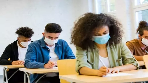 Students in a classroom with masks on.