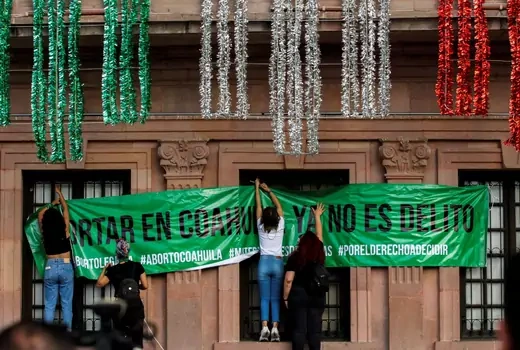 Women hang up a banner that says "Abortion in Coahuila is no longer a crime" following the Mexican Supreme Court ruling that decriminalized abortion.