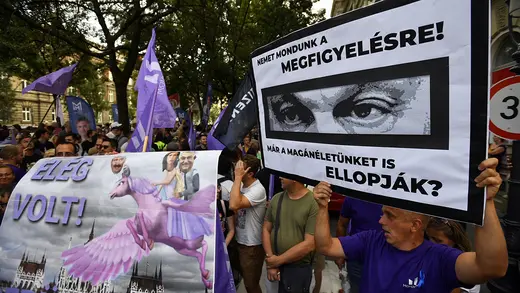 A protester's poster shows Prime Minister Viktor Orban's eyes and reads "We say no to your observation! Do you want me to steal our privacy?" 
