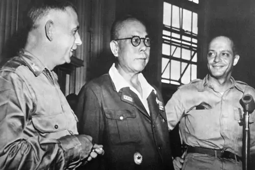 Japanese General Yamashita Tomoyuki is seen at his trial surrounded by two smiling U.S. military officers