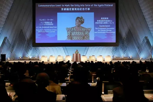 Photo showing Kenyan environmental activist and Nobel Peace Prize winner Wangari Maathai talking at podium in front of large screen with her image.