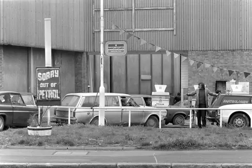 Cars line up for their ration of gas in Surrey, Britain. A sign reads "Sorry out of petrol".