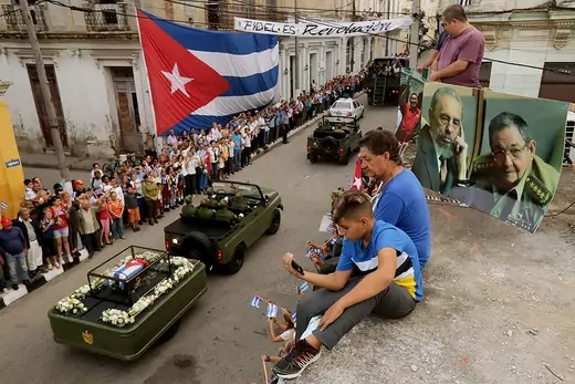  People sit on their rooftop to get a better view as the remains of former Cuban President Fidel Castro pass by on their cross-country journey from Havana to Santiago de Cuba.