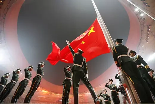 Soldiers raise China's national flag in the Olympic stadium. 