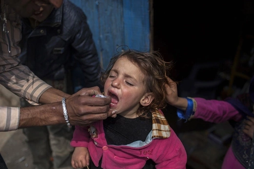 A health worker gives polio vaccine drops to a child in Islamabad, Pakistan, in February 2014.