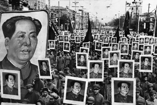 Crowds display posters of Chinese Communist Party leader Mao Zedong during a celebration of the party’s victory.