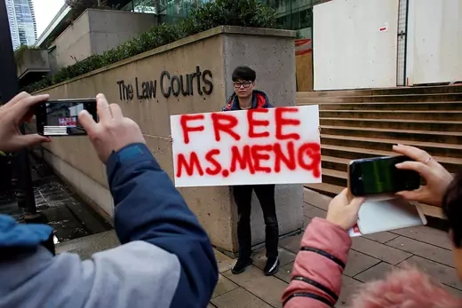 A man holds a sign outside of the B.C. Supreme Court bail hearing of Meng Wanzhou.