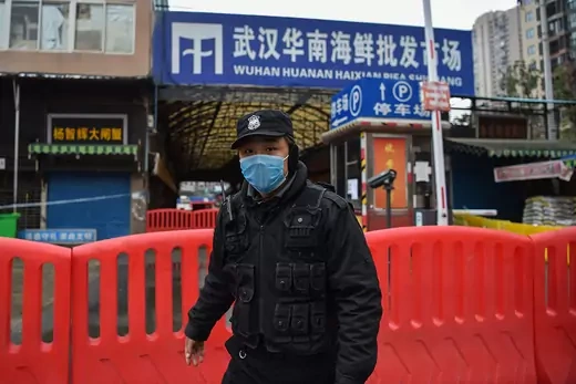 A security guard wears a mask in front of a blocked animal market in Wuhan, China.