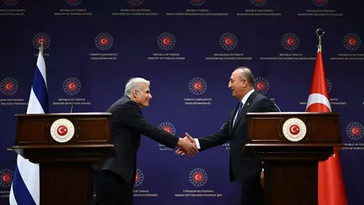 Israeli Foreign Minister Yair Lapid and Turkish Foreign Minister Mevlut Cavusoglu shake hands during a press conference