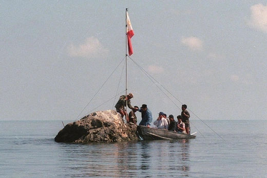 Philippine Navy personnel plant a flag at the disputed Scarborough Shoal. 