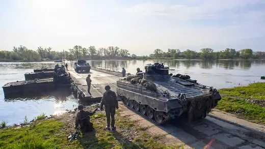 A Marder infantry fighting vehicle rolls ashore from a floating bridge in Saxony, Germany.. 