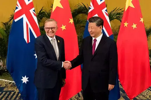 Australian Prime Minister Anthony Albanese shakes hands with Chinese President Xi Jinping in front of Australian and Chines flags.