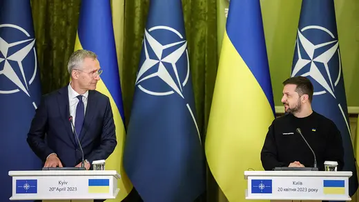 NATO chief Jens Stoltenberg and Ukrainian President Volodymyr Zelenskyy stand at lecterns in front of the NATO and Ukrainian flags
