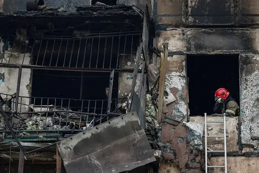 A rescuer wipes their face while working in a residential building heavily damaged by a Russian missile strike in the Dnipropetrovsk region.