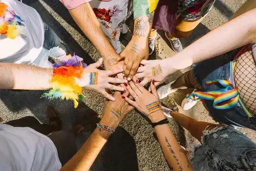 People with their hands in at a Pride event