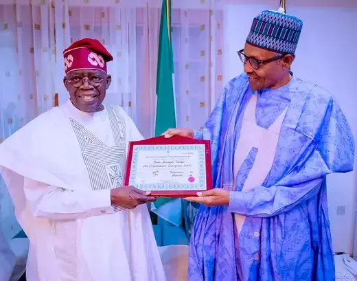 Former Nigerian President Muhammadu Buhari and Nigeria's newly declared winner of 2023 presidential election, Bola Tinubu stand side by side holding a certificate.